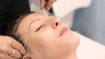 photo of woman getting threaded eyebrows