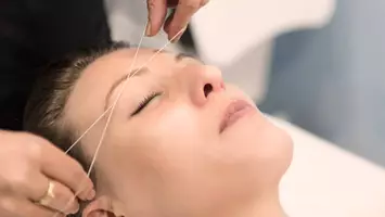 photo of woman getting threaded eyebrows