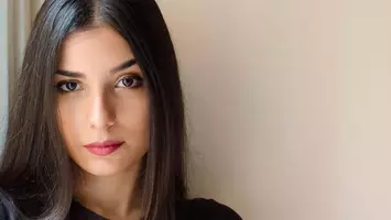 woman with straight hair staring at the camera on pink background