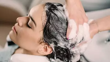woman getting hair shampooed best moisturizing shampoos