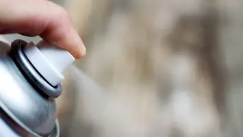 artist spraying alcohol in hair products