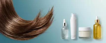 Macro shot of shiny, smooth hair strand and four split end treatment products on a white background.