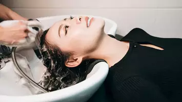 photo of woman getting hair shampooed in sink