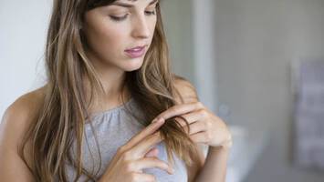 photo of woman examining her damaged hair