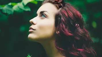 woman with dark brown hair with red highlights