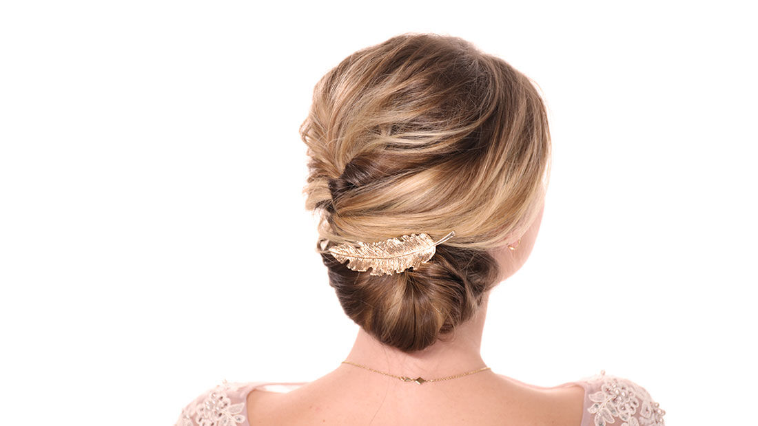 woman's updo back view with gold feather clip