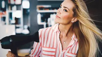 photo of woman blow dying hair how to blow dry fine hair