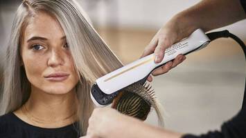 photo of woman getting hair straightened