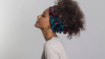 photo of woman with curly hair wearing head wrap accessory