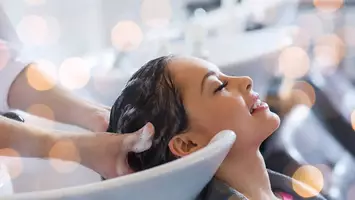 Woman getting shampoo in hair