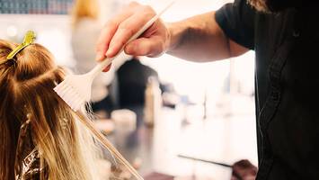 man coloring woman's hair in salon