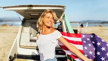 woman with side braid hairstyle holding american flag