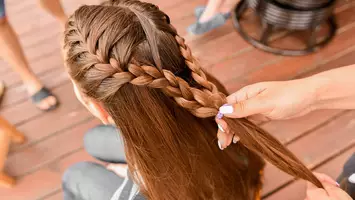 woman styling half braided ponytail hairstyle on long hair
