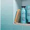 A clean and bright bathroom countertop/sink area featuring various hair accessories like a hair brush, hair clips, comb, scrunchie, etc. Also showing products mentioned in the article like: EverPure Glossing Treatment and Diamond Sleek Spray
