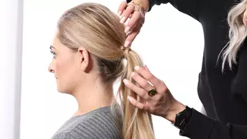 photo of stylist demonstrating how to style a low ponytail