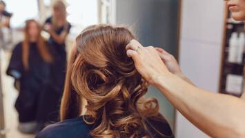 photo of stylist curling hair polished hairstyles