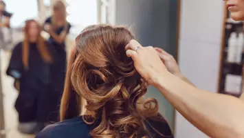 photo of stylist curling hair polished hairstyles