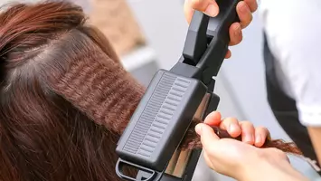 photo of stylist using a hair crimper