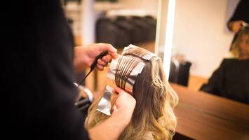 photo of woman getting foil balayage in salon