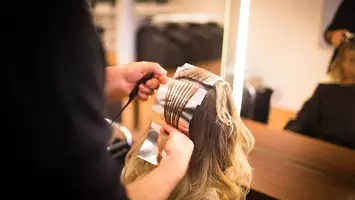 photo of woman getting foil balayage in salon