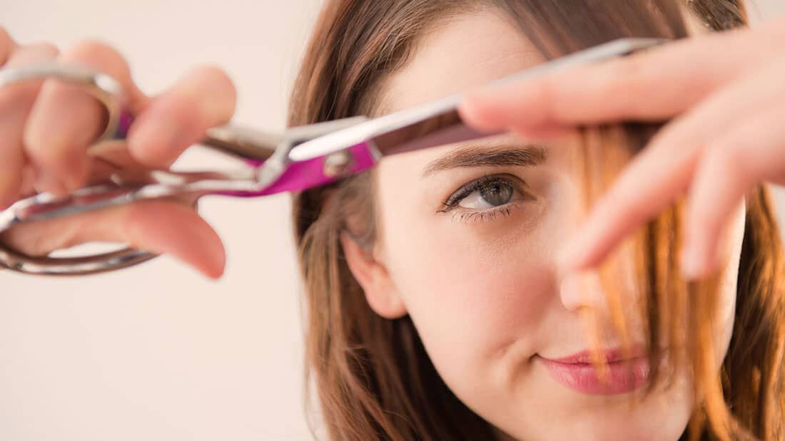 woman cutting her own breakup hair