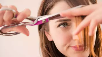 woman cutting her own breakup hair