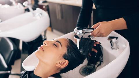 woman getting hair shampooed at salon with shampoo for dry hair