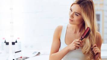 photo of woman brushing her hair