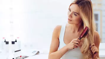 photo of woman brushing her hair