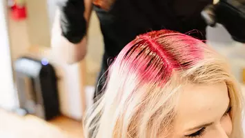 photo of stylist applying hair makeup to woman's hair