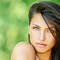 woman with long brown hair under a tree