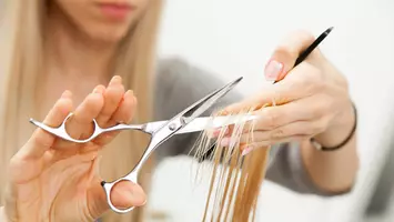 close up of stylist cutting hair in salon