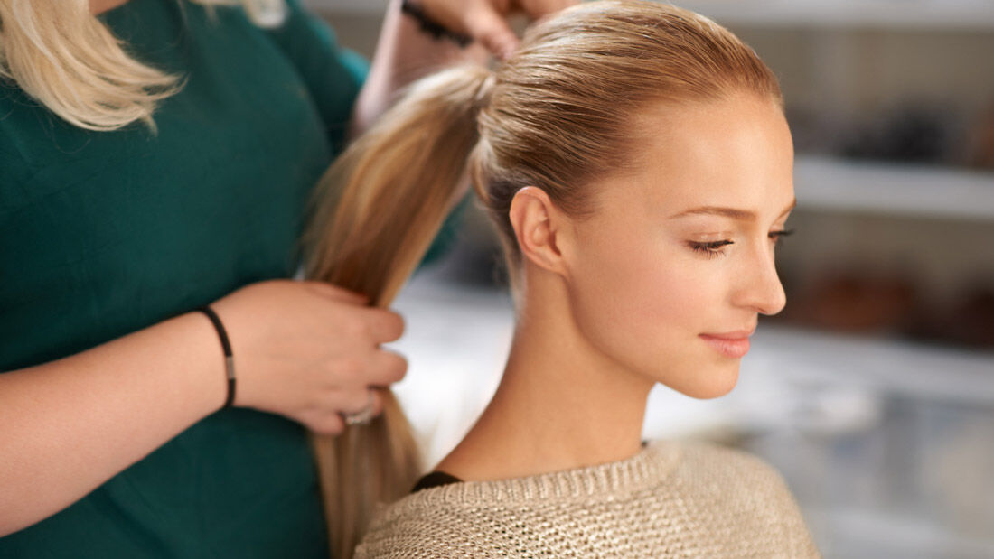 Woman with a low ponytail getting a bamboo braid