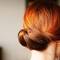 woman with balayage red hair in a bun