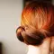 woman with balayage red hair in a bun