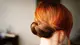 woman with balayage red hair in a bun