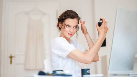 photo of woman using hairspray