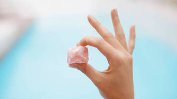 photo of woman holding rose quartz crystal