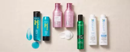 Flat lay showing Matrix High Amplify Shampoo, Matrix High Amplify Conditioner, Redken Volume Injection Shampoo, Redken Volume Injection Conditioner, Redken Root Lifter Volumizing Spray Foam, Biolage Volume Boost Shampoo, and Biolage Volume Boost Conditioner, with texture swatches of shampoo and mousse on a white background.