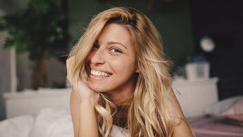 woman in bed using hair sleep products