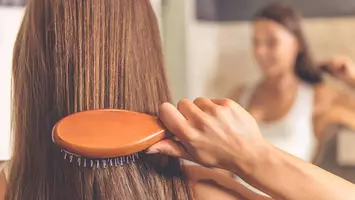 close up photo of woman brushing her hair