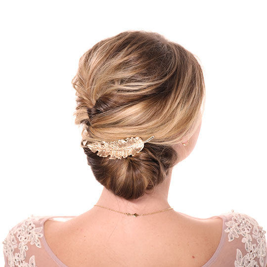 woman's updo back view with gold feather clip