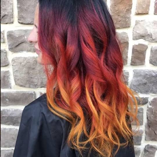 A woman with a beautiful magenta hairstyle