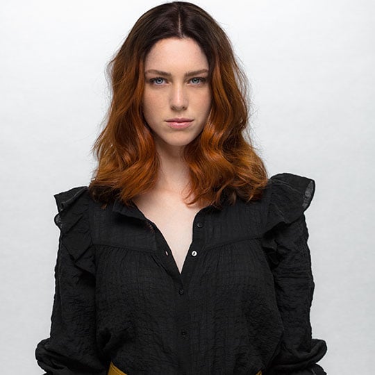 a woman with shoulder-length copper hair