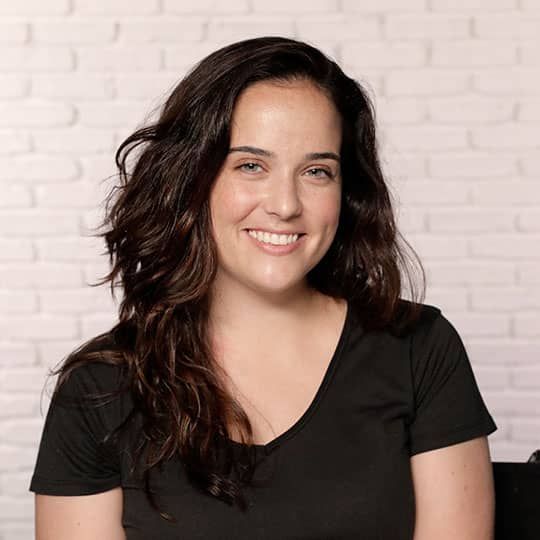 woman with dark brown hair smiling showing hairline