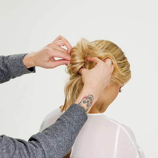 man pinning woman's hair for new year's eve bun