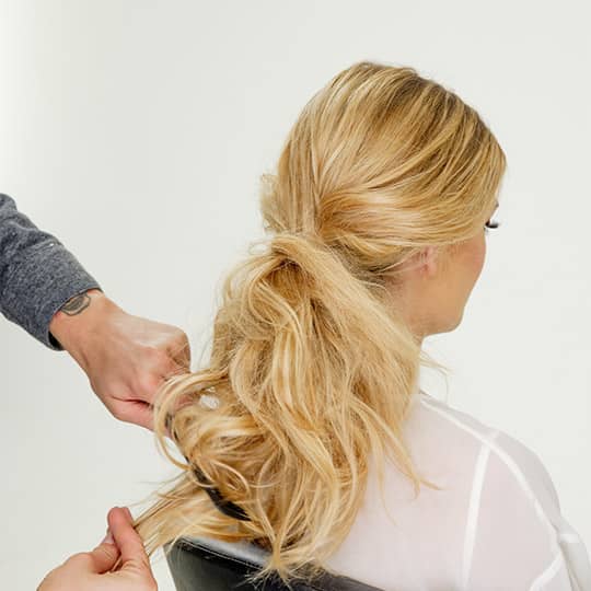 man teasing woman's hair for new years eve bun