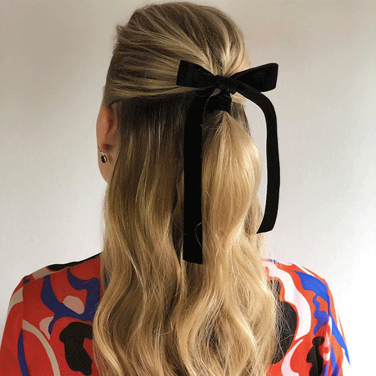 black of woman with half up black bow red carpet style