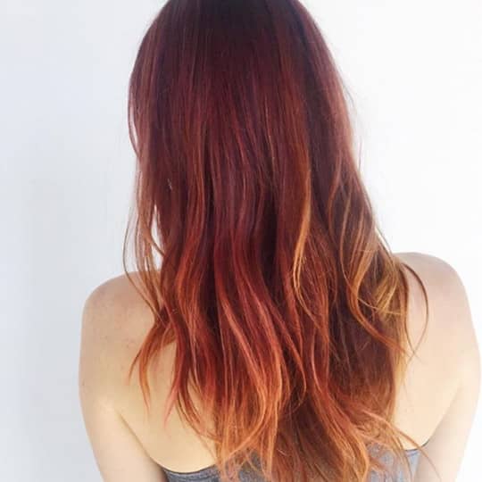A woman with a beautiful magenta hairstyle