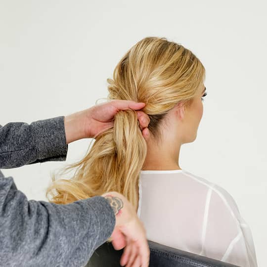 man styling woman's new years eve bun